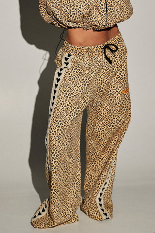 Person wearing a leopard print tracksuit on a white background